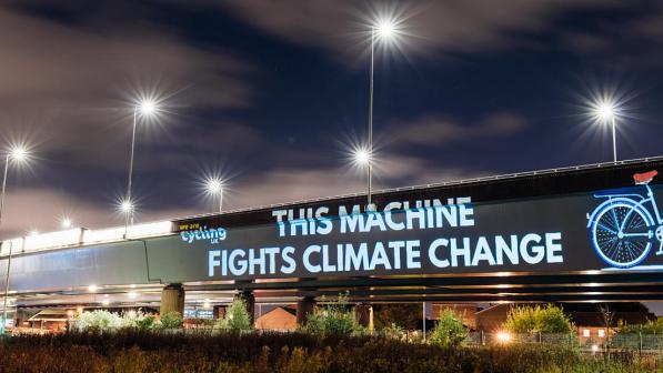 A campaign message projected onto a road overpass