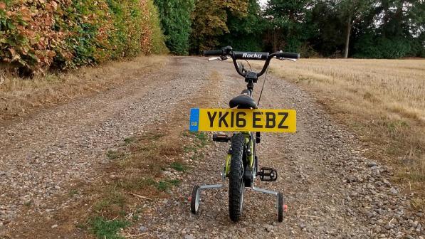 A childs cycle with license plates.