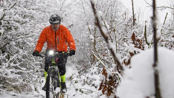 A mountain biker out riding in heavy snow. 