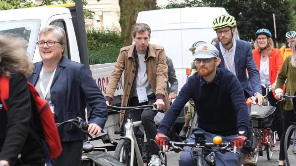 Cyclists riding along a street at the beginning of bike week. 