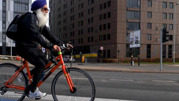 A man cycling along cycle lanes in Birmingham