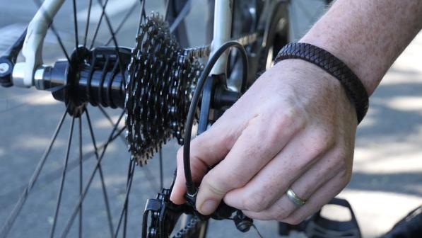 A cyclist performing roadside repairs. 