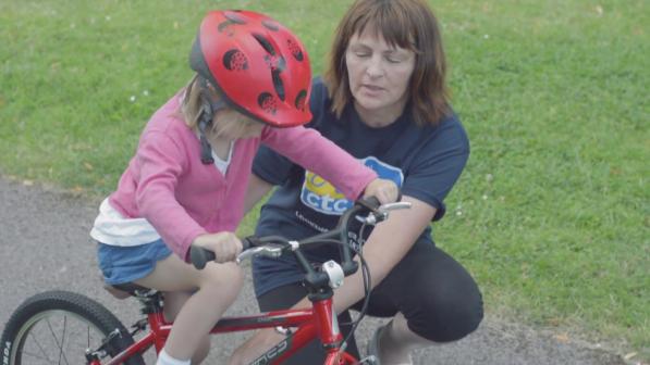 Julie teaches a four year old girl to learn to ride a bike