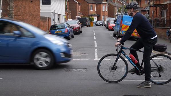 A cyclist negotiating a right turn at a junction.