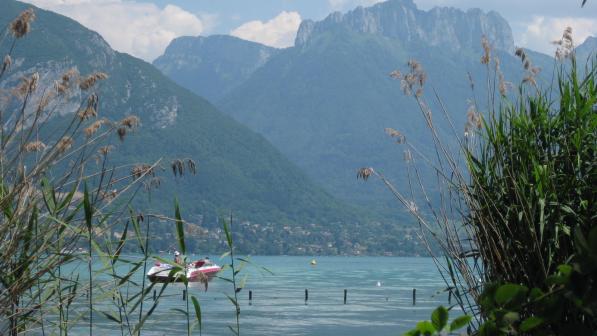 View of a lake with mountains behind it and a boat on the water