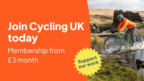 A man riding through a puddle on a gravel bike. The text reads 'Join Cycling UK today - membership from £3 a month'