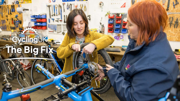Two woman performing maintenance on a bike together