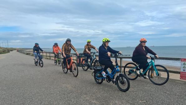 Six cyclists, including people riding electric and adapted cycles, take part in a group ride along Aberdeen Beach Esplanade.