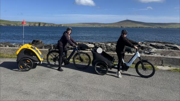 Two cyclists riding along the seafront