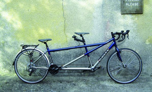Dawes Galaxy Twin, a blue and silver tandem bike leaning against a concrete wall with a crack in it