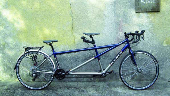 Dawes Galaxy Twin, a blue and silver tandem bike leaning against a concrete wall with a crack in it