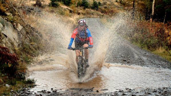 Mountain biker splashing through a stream