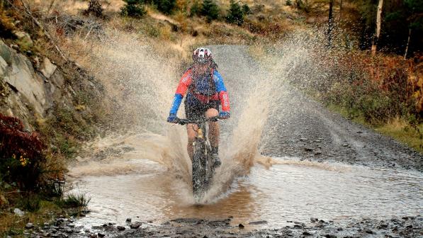 Mountain biker splashing through a stream