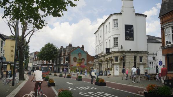 Town city centre scene with people walking and people using a cycle lane
